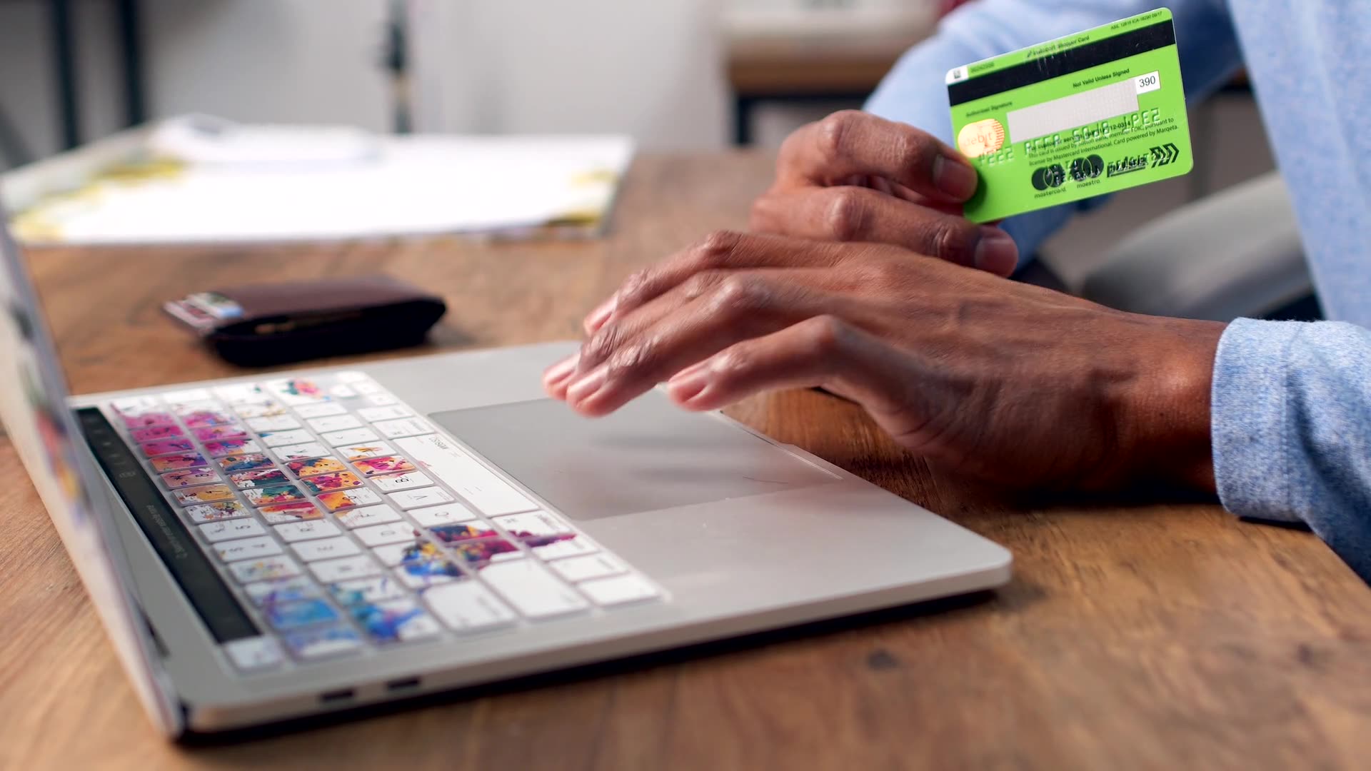 Website cost in Nigeria: a person holding a bank card while shopping on a laptop