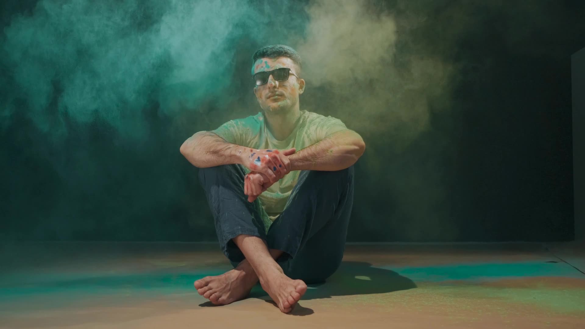 A man sitting in a cloud of coloured smoke
