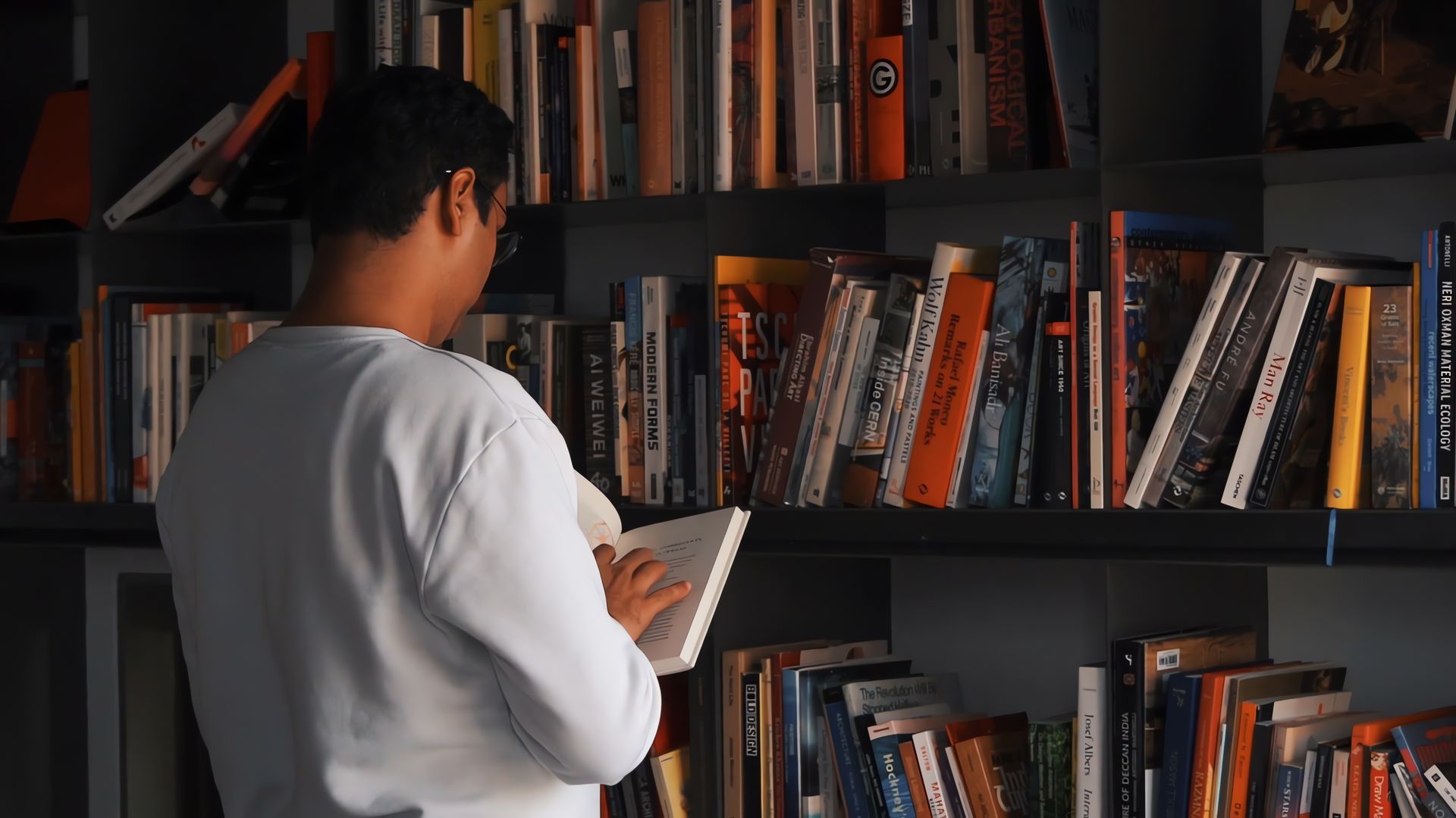 Business name in Nigeria: a man reading in front of full bookshelves