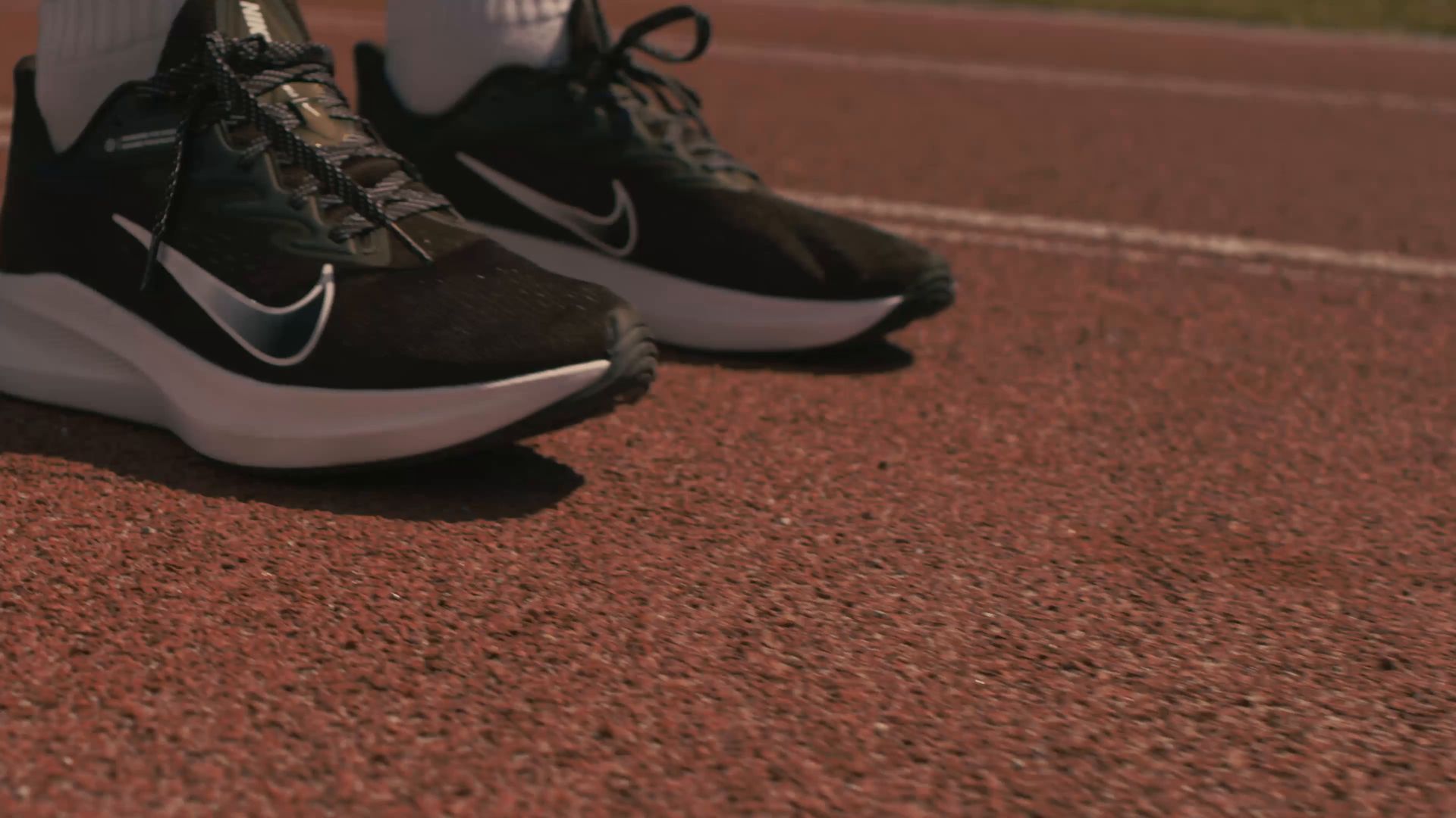 A runner's shoes on the start line of a track