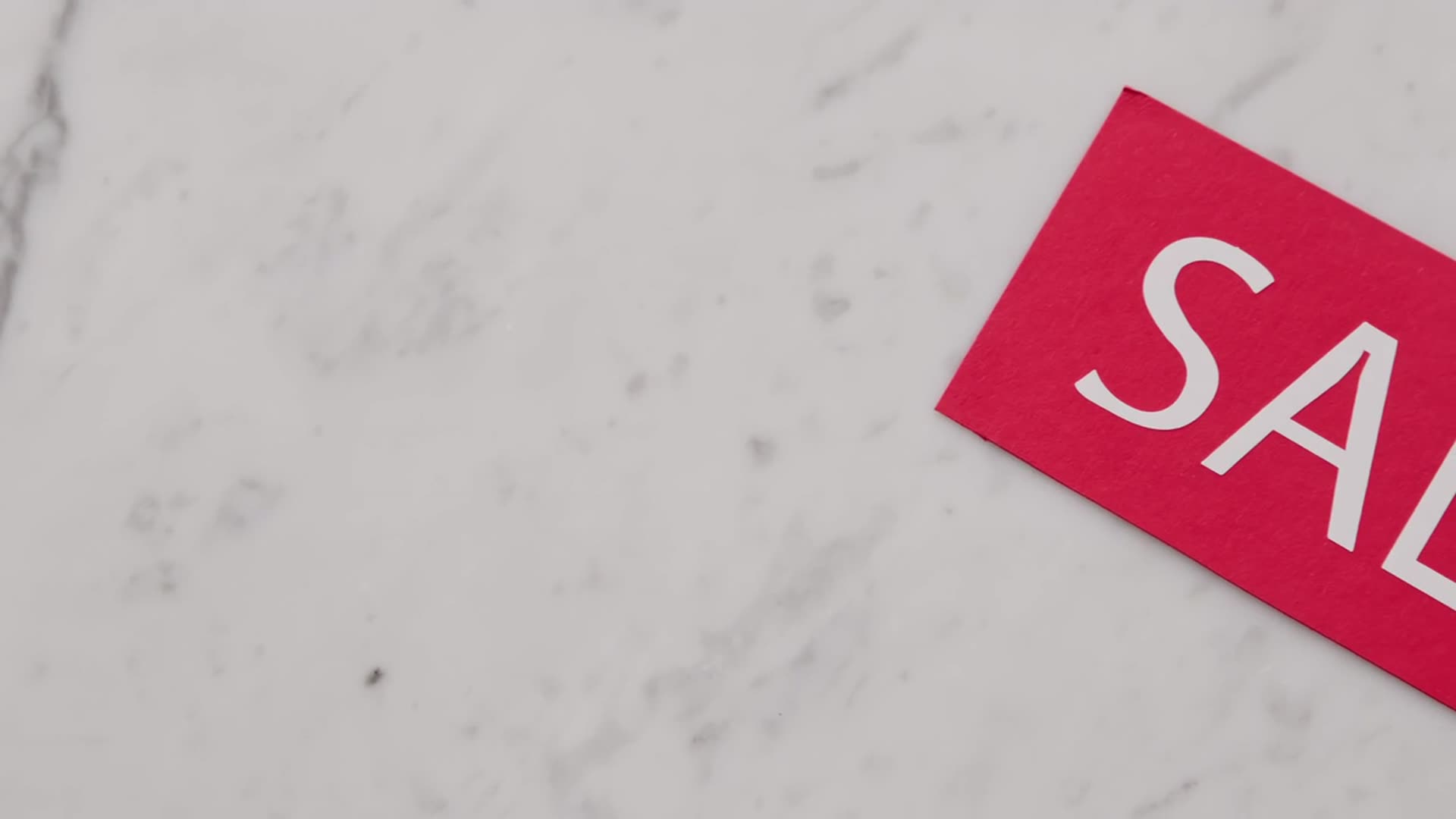 A red sale tag on a marble surface