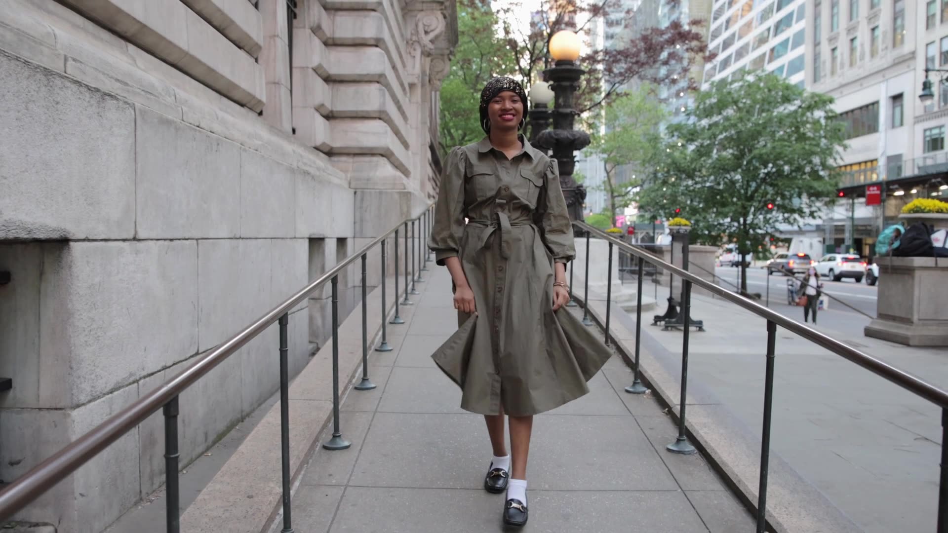 A woman walking along a city pavement