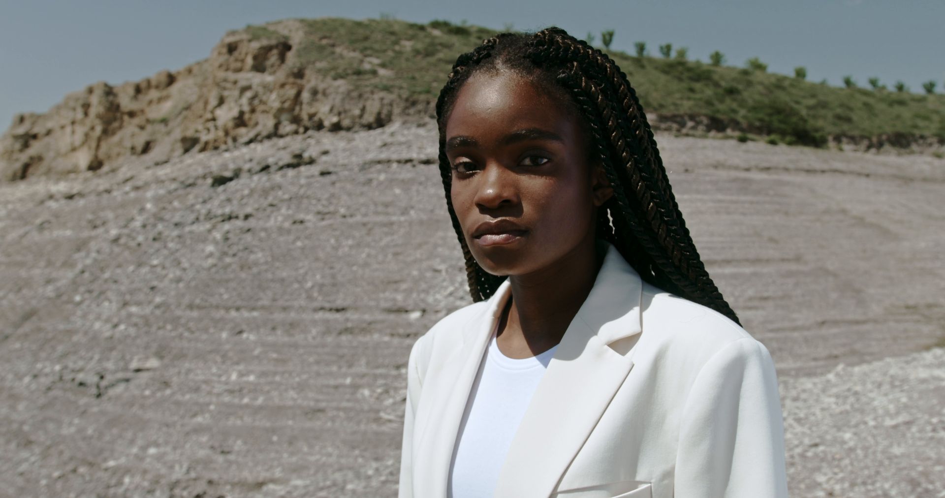A woman in a white blazer standing outdoors